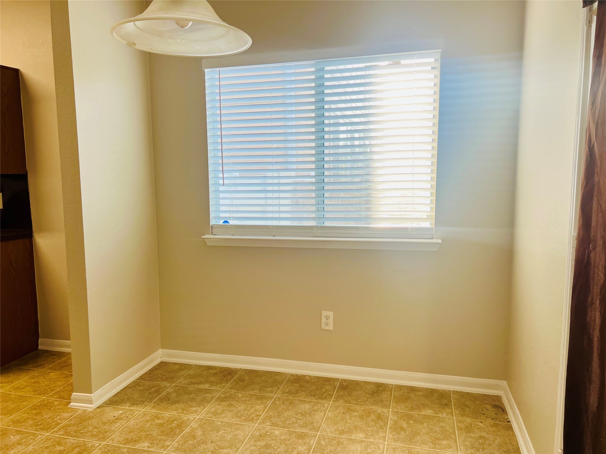 Bright, cozy nook featuring a large window with blinds, perfect for a breakfast area or reading corner.