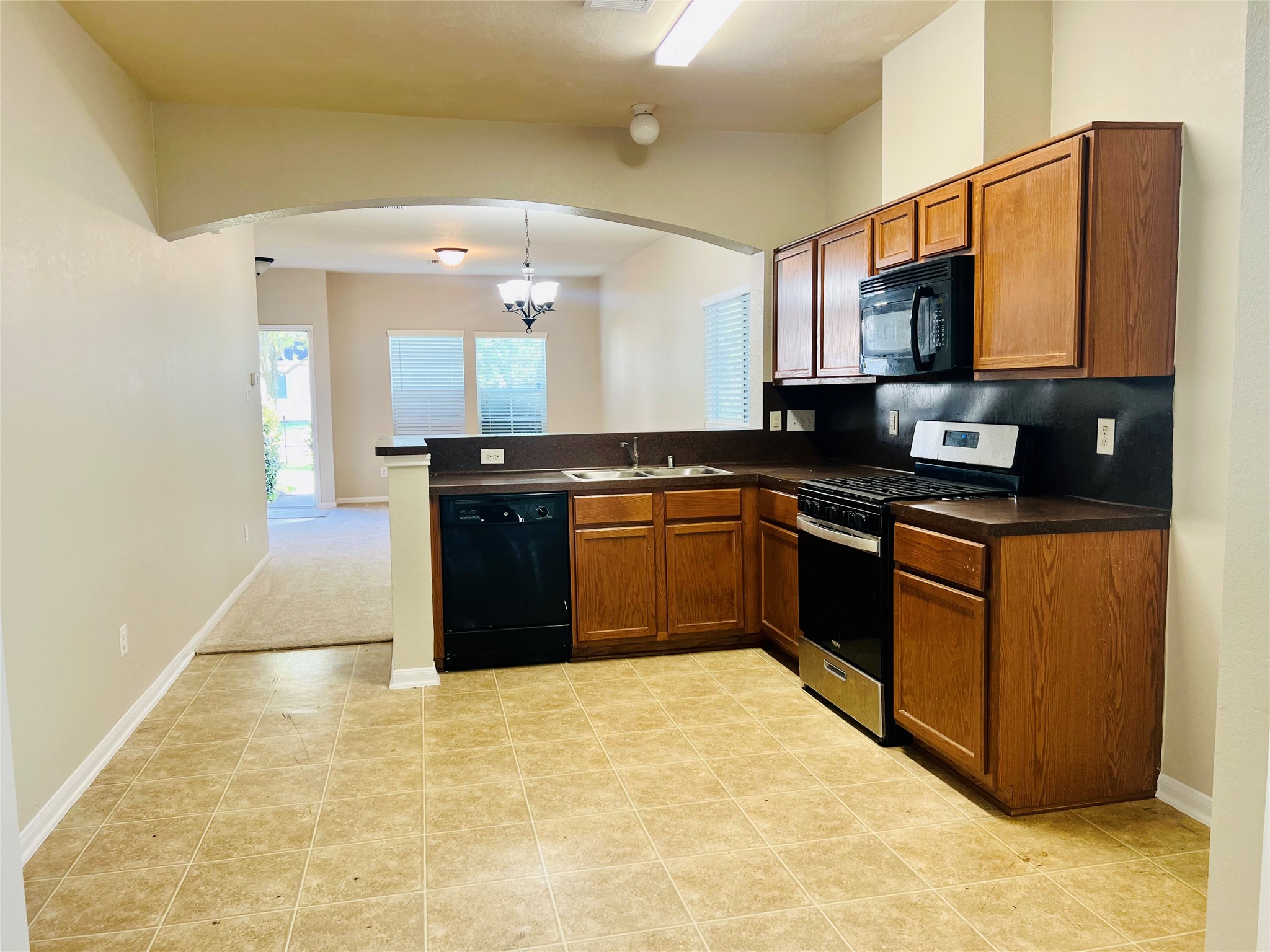 Spacious kitchen with modern appliances, ample cabinet space, and an open layout leading to a bright dining area.
