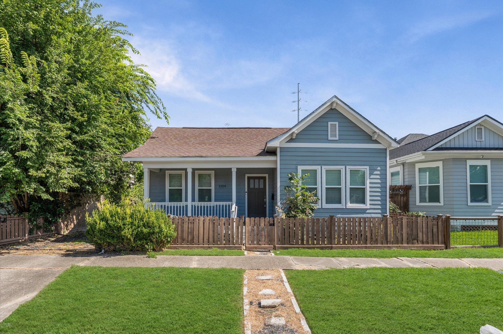 Charming single-story blue home with a welcoming front porch and neatly fenced yard. Features a well-maintained lawn and a cozy walkway leading to the entrance. Ideal for those seeking a quaint, comfortable living space. Charming single-story blue home with a welcoming front porch and neatly fenced yard. Features a well-maintained lawn and a cozy walkway leading to the entrance. Ideal for those seeking a quaint, comfortable living space.