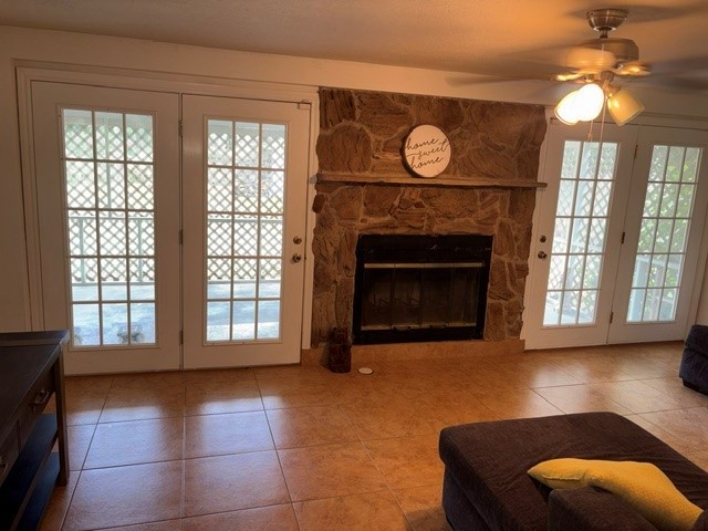 A view of the large family room with doors that open to the large covered patio and a wood burning fireplace.