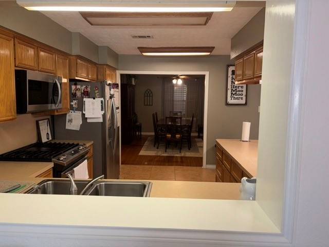 A view from the family room through the kitchen window above the sink into the kitchen and the dining room.