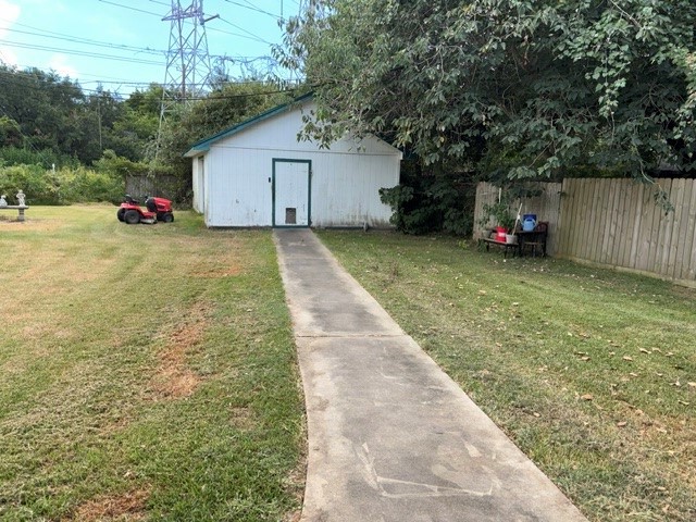 A view of the large workshop  in the back yard, In addition to the workshop area there are also 2 small rooms with window a/c units that could be craft rooms or some other use.