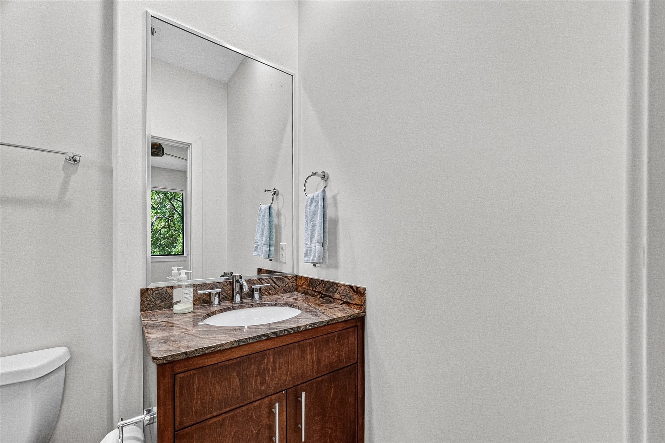 Elegant bathroom in bedroom on third floor with a sleek granite countertop, and modern fixtures.
