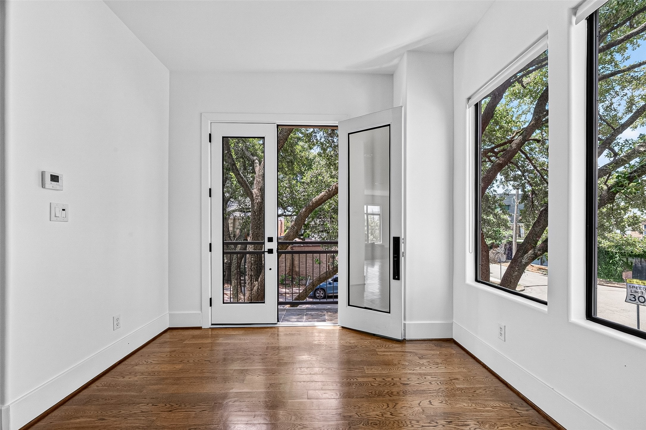 Bright and inviting breakfast area featuring large windows and French doors leading to a charming balcony, perfect for enjoying natural light and outdoor views.
