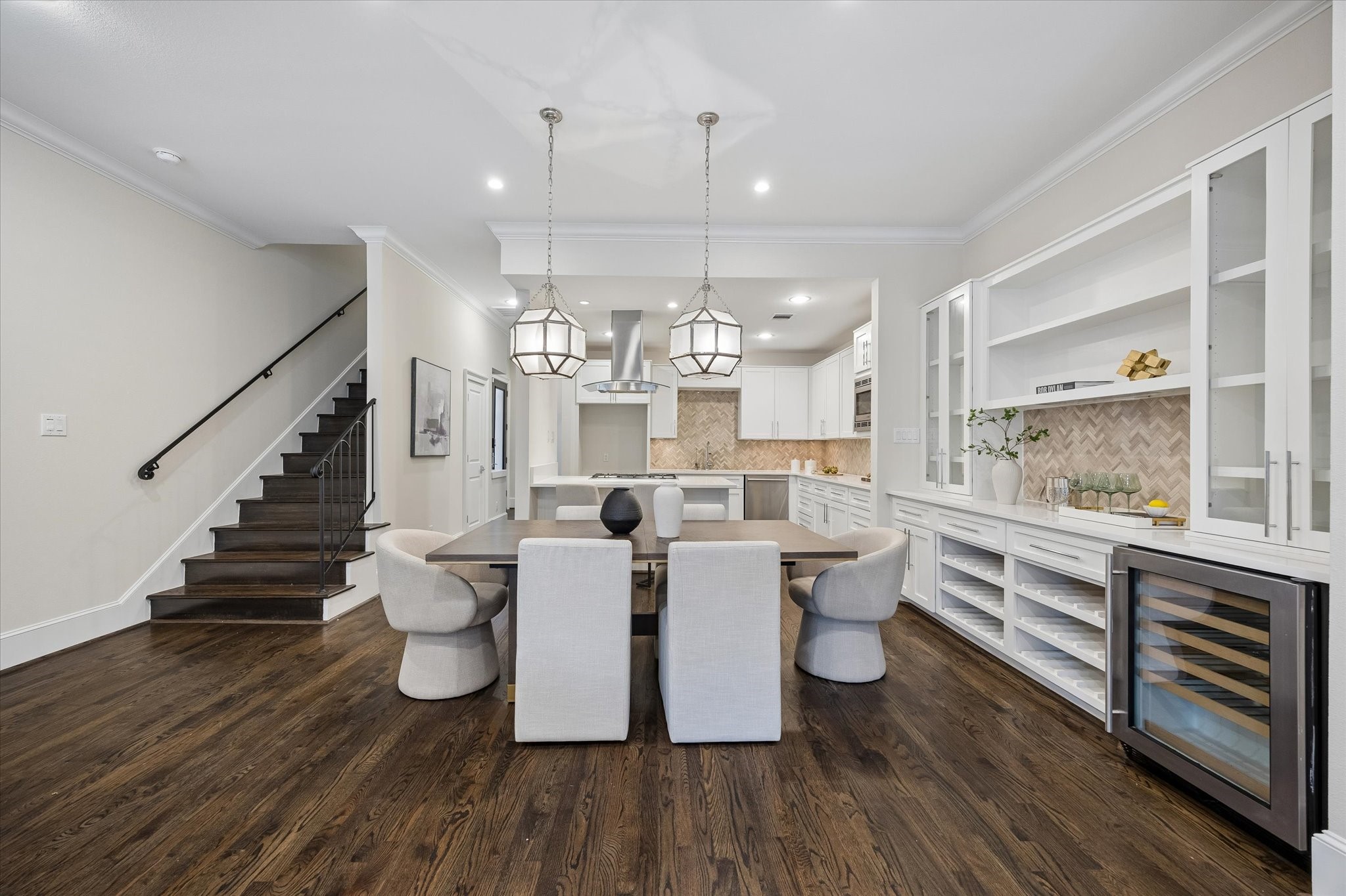 Enjoy meals beneath stylish pendant lighting while showcasing your favorite pieces in the built-in shelving and cabinetry. A conveniently located beverage refrigerator adds both function and ease to the dining area. Enjoy meals beneath stylish pendant lighting while showcasing your favorite pieces in the built-in shelving and cabinetry. A conveniently located beverage refrigerator adds both function and ease to the dining area.