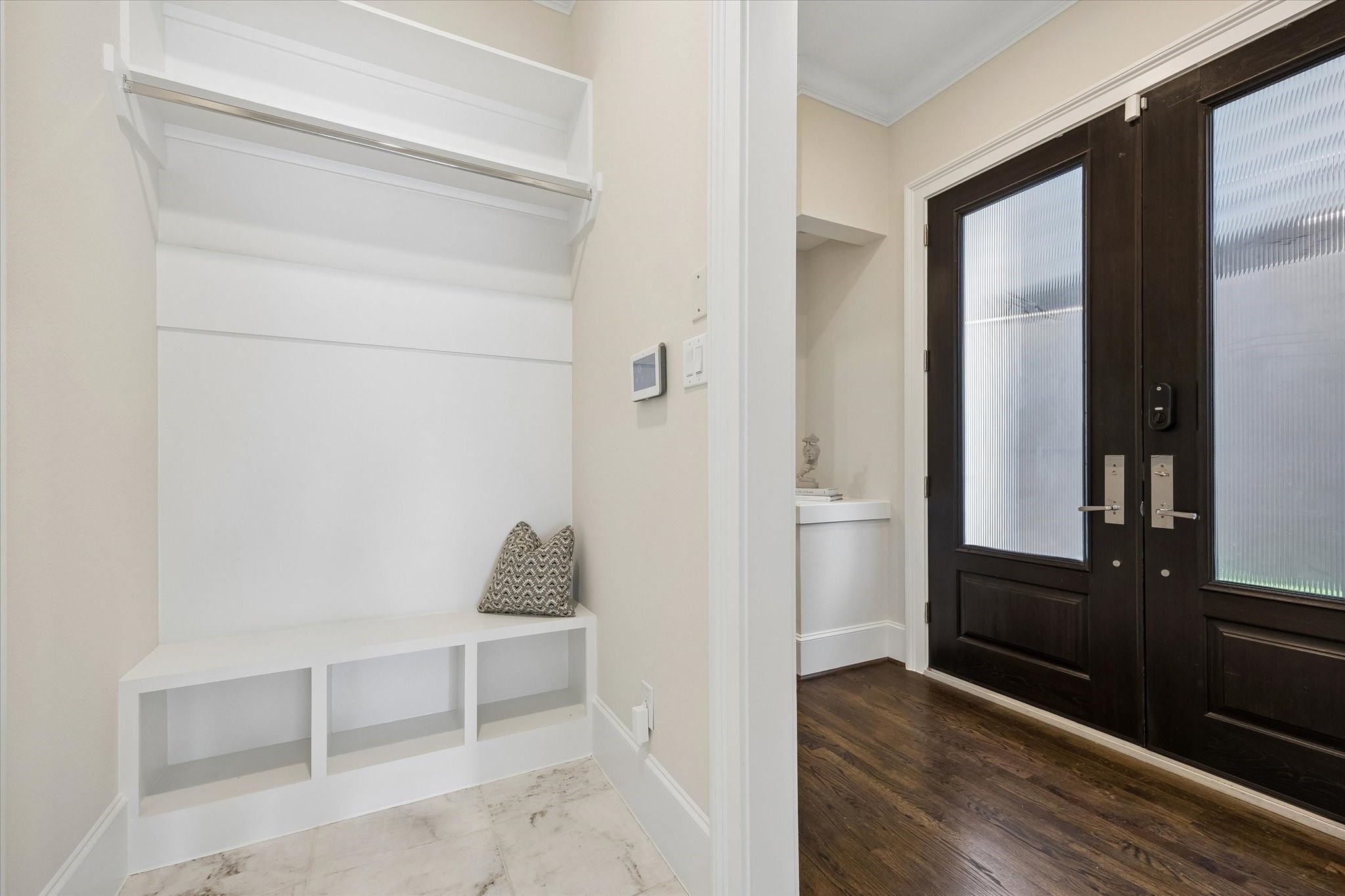 Located just off the garage and front door, the mudroom offers bench seating, open shelving and a hanging bar- perfect for staying organized.