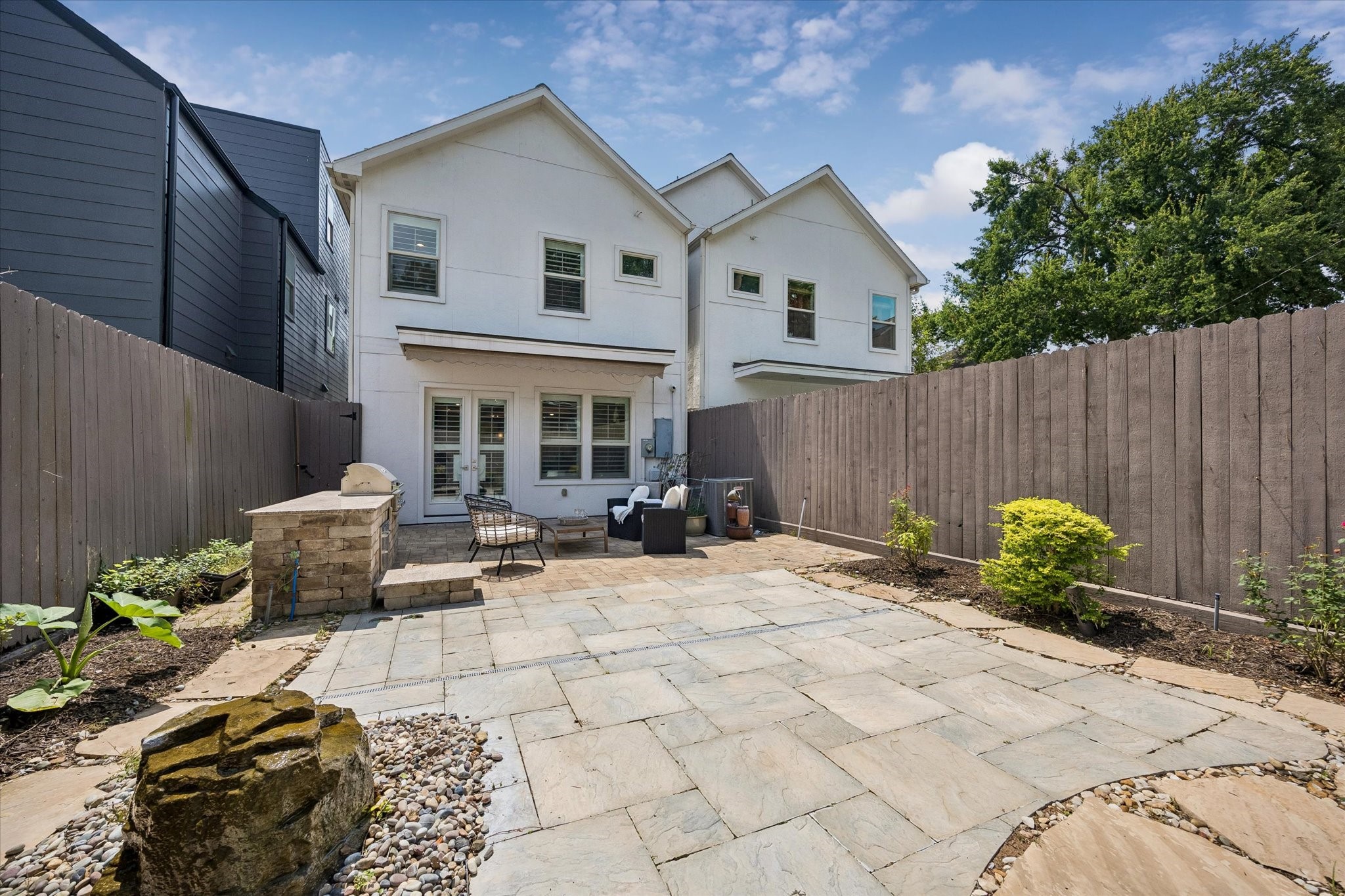 Featuring a water feature, the low-maintenance backyard offers a tranquil retreat for relaxing or entertaining friends and loved ones.