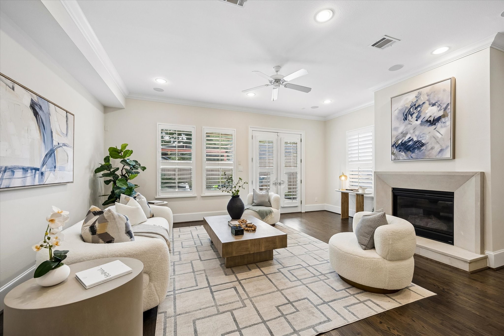Anchored by a cast stone fireplace, the spacious living room features hardwood floors, built-in speakers, recessed lighting, a ceiling fan, and windows that overlook the backyard. Anchored by a cast stone fireplace, the spacious living room features hardwood floors, built-in speakers, recessed lighting, a ceiling fan, and windows that overlook the backyard.
