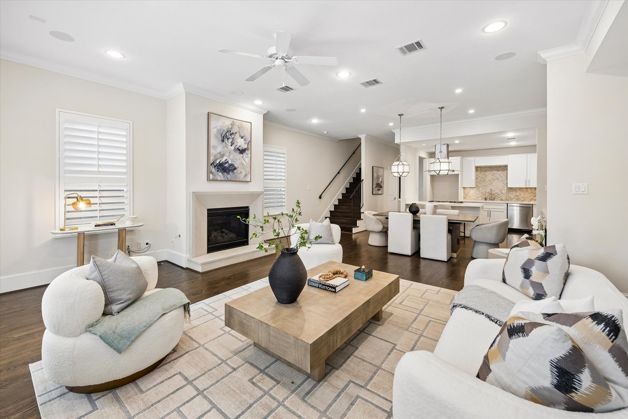 The open layout shines with rich hardwood floors and a living room centered by a cast stone fireplace.