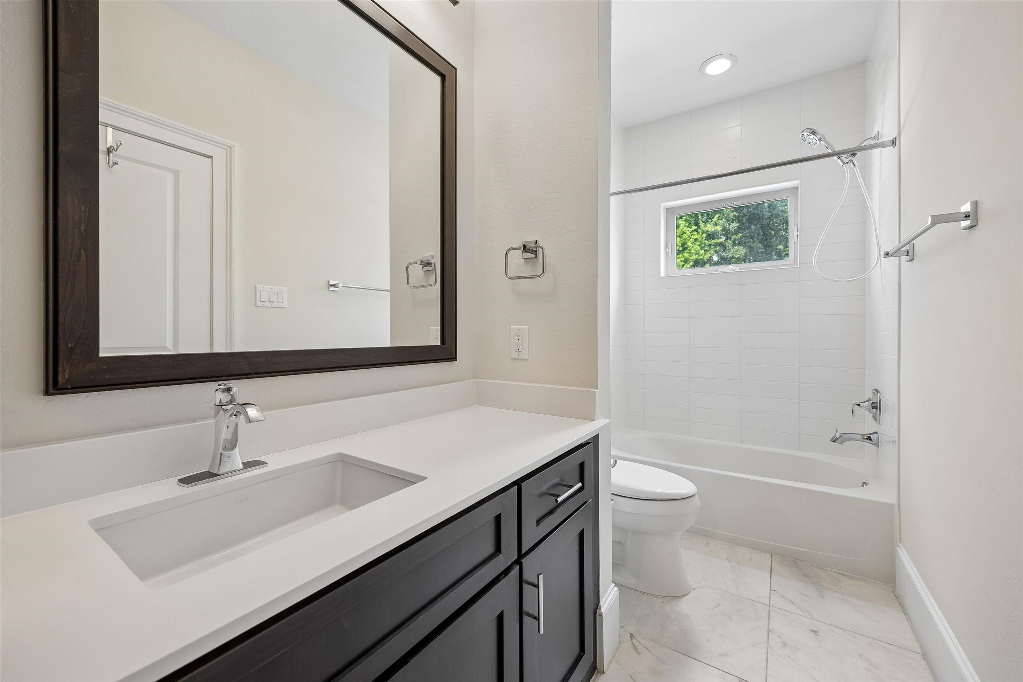 This full bath with a shower/tub combo offers convenient access from both a secondary bedroom and the home office/4th bedroom.