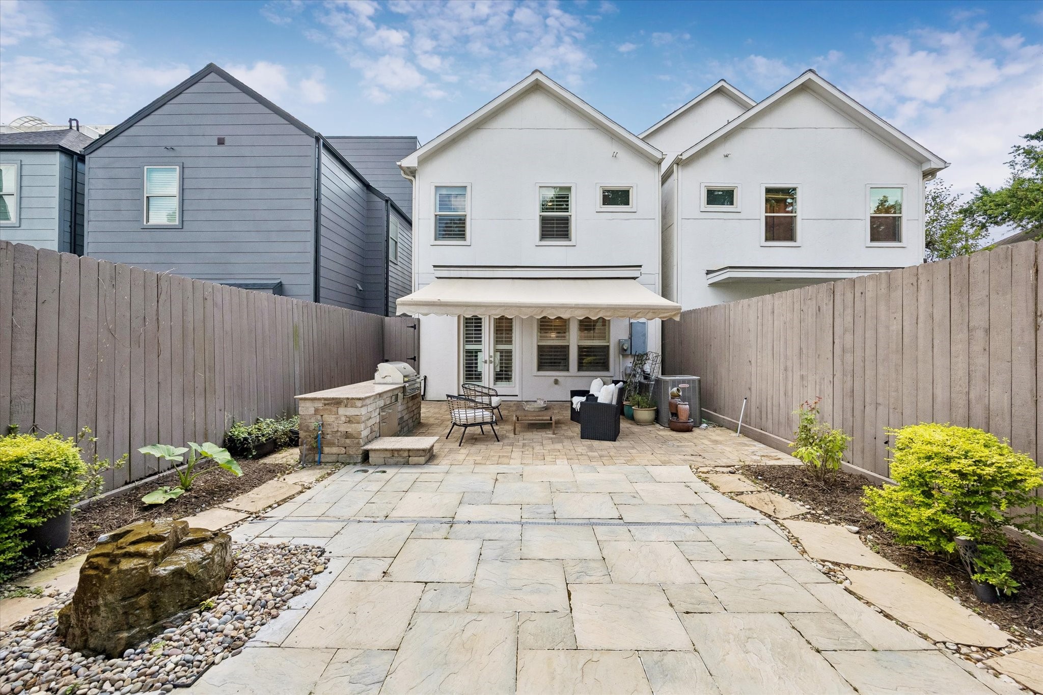 Outside, your low-maintenance oasis awaits, featuring a retractable awning, soothing water feature and a built-in outdoor grill with granite counters and storage.