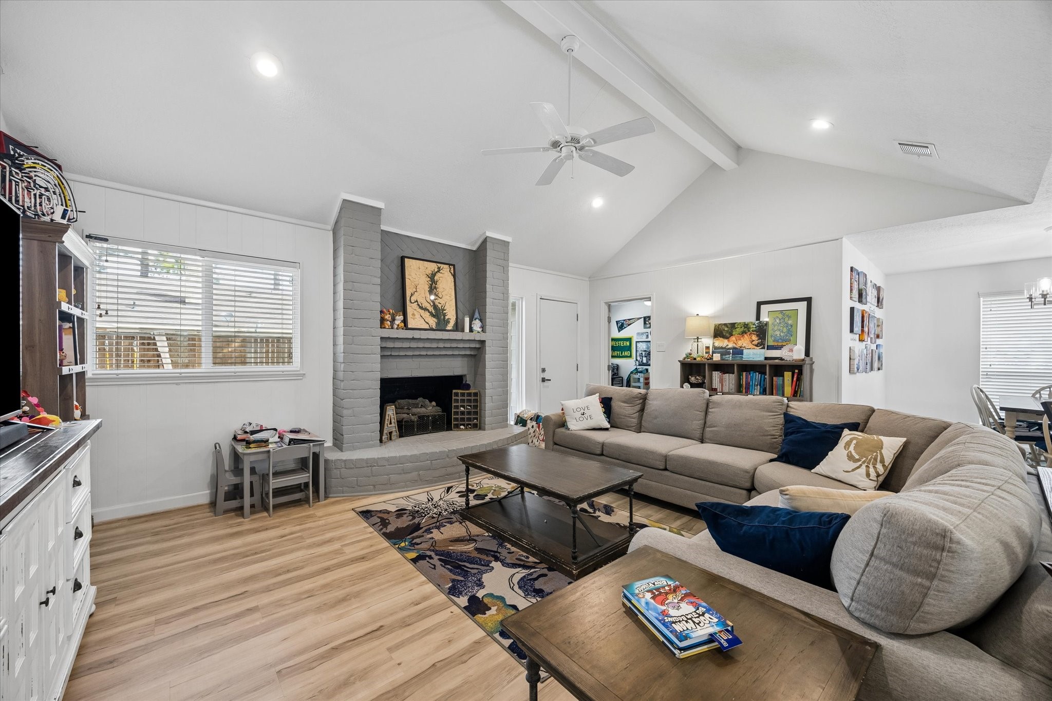 Another view of fireplace & recently upgraded windows, with door leading spacious fenced back yard.