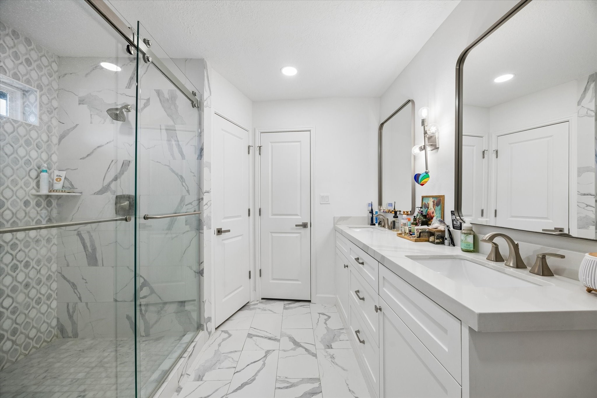 Another view of primary bathroom renovation boasting custom tile work in shower plus two spacious walk-in closets!