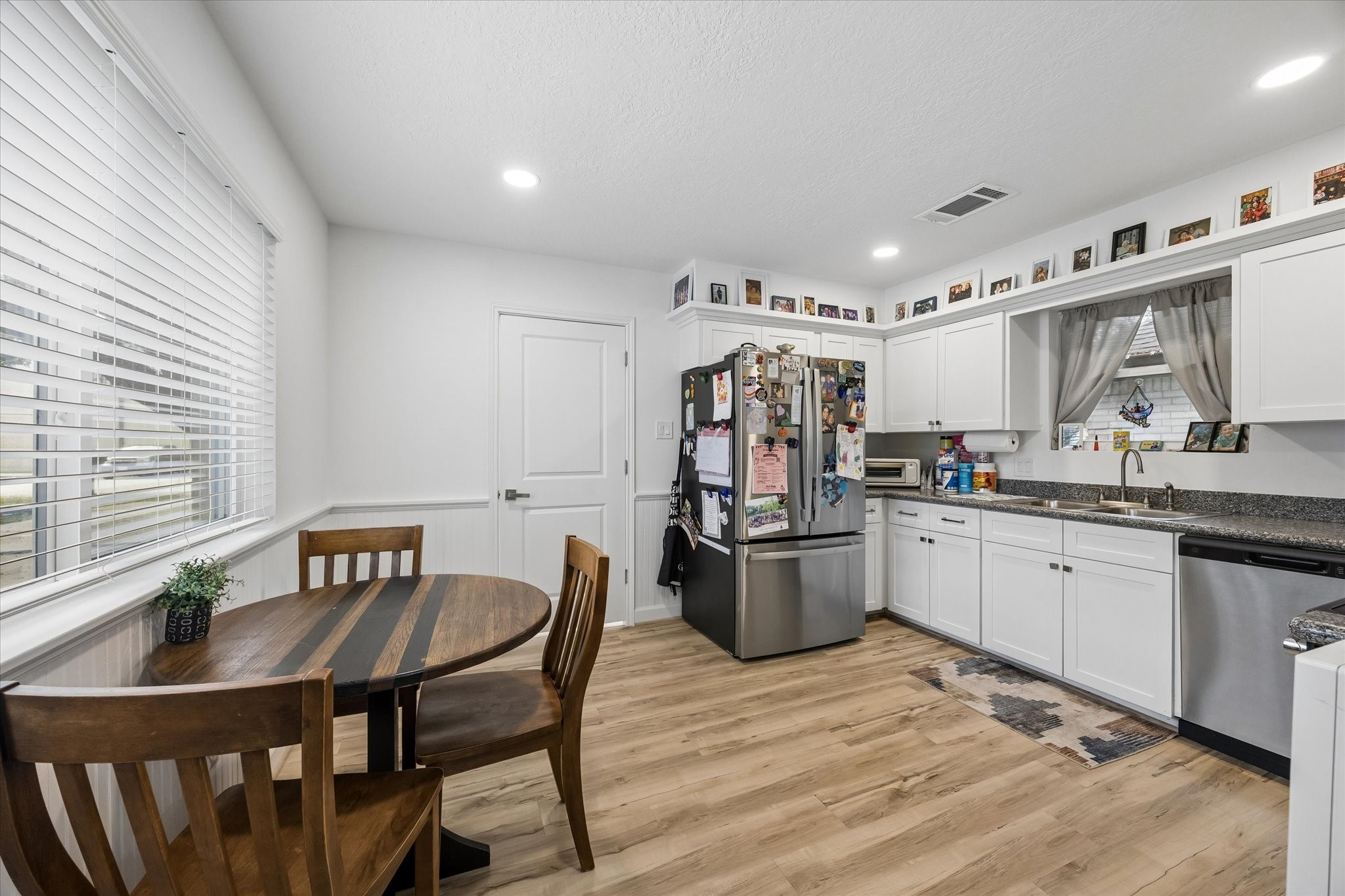 Fabulous chef's kitchen boasts granite counters, high-end LVP flooring & stainless appliances, including refrigerator!