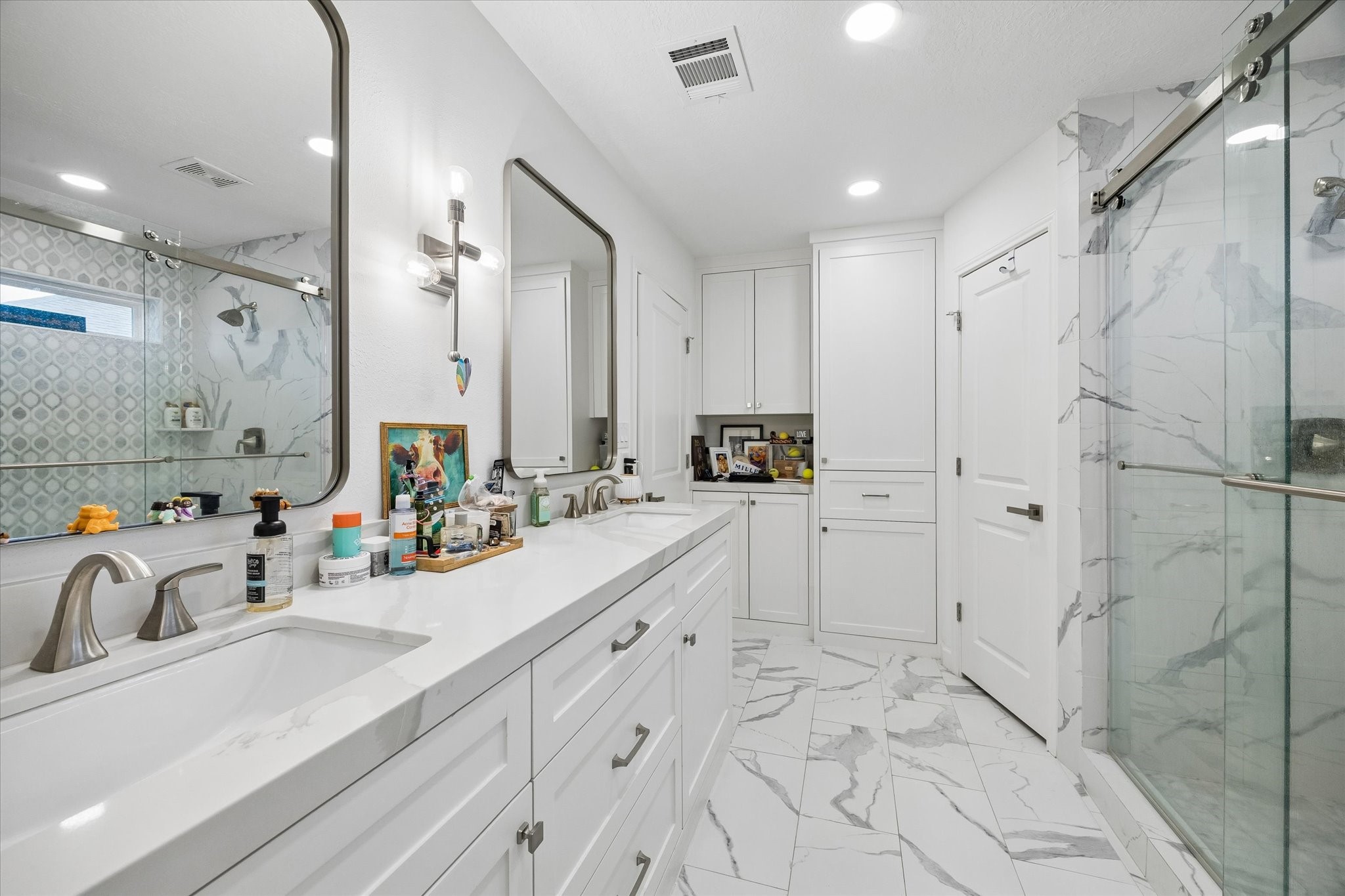 Exquisite & complete high-end renovation creates a spa-like experience with the primary bath. Quartz counters, dual undermount sinks, huge walk-in shower with glass surround, framed mirrors, oversize tile flooring & upgraded fixtures/hardware complete this beautiful renovation!