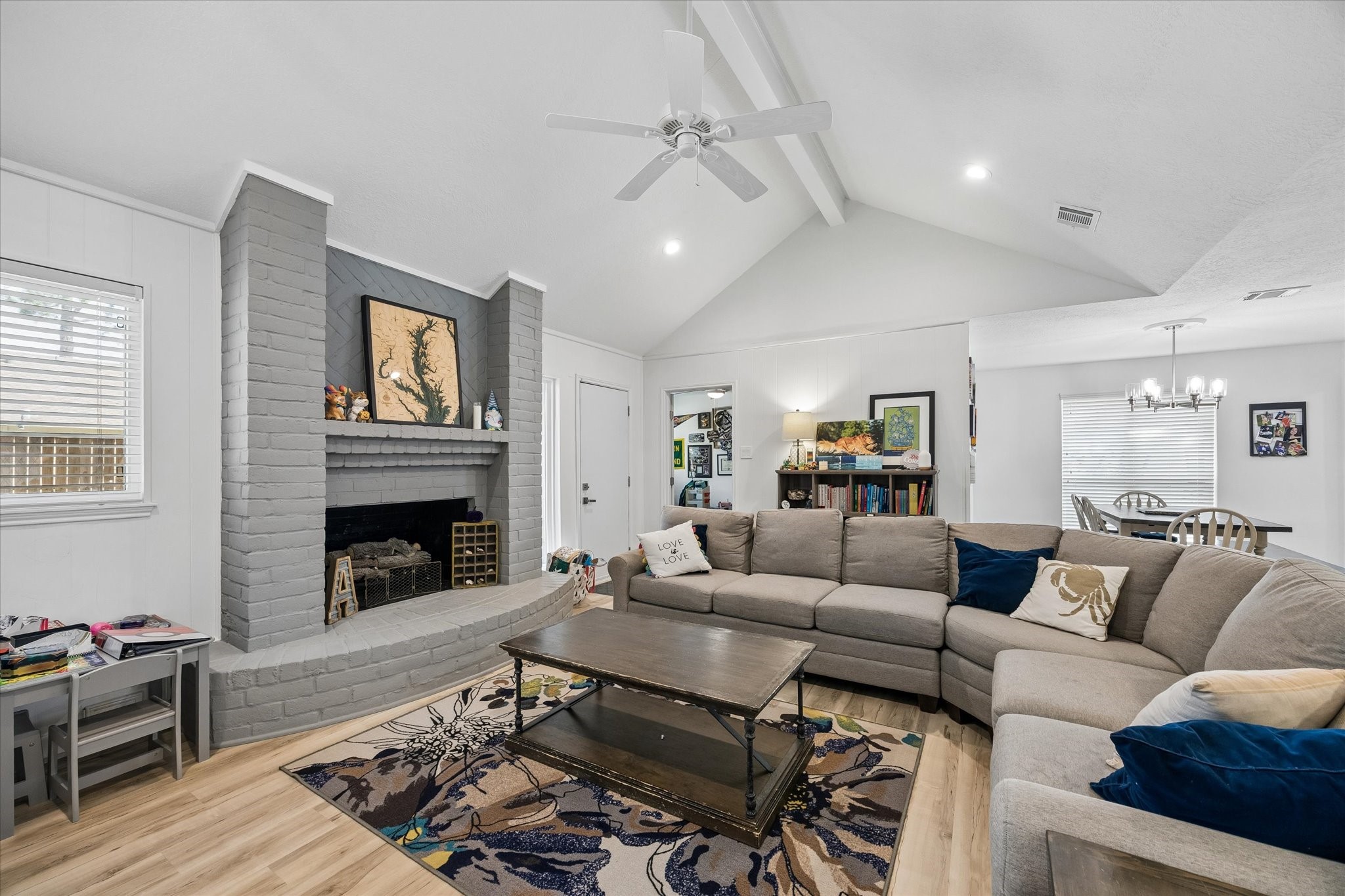 Stately brick fireplace with gas logs & mantle painted in fashionable tones. Note high-end dual pane windows, which were replaced throughout home.