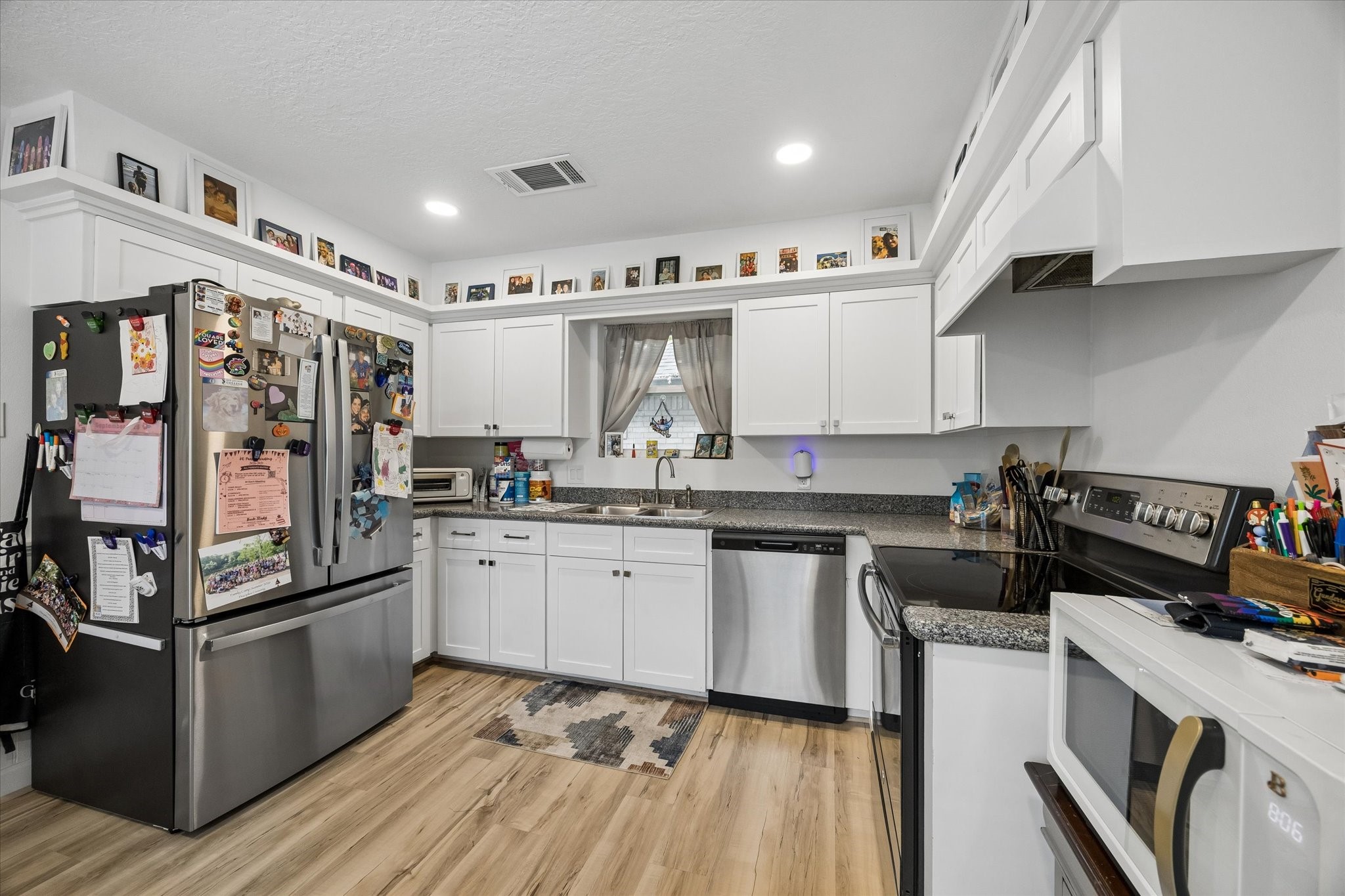 Another view of beautiful kitchen, boasting recessed lighting & abundant cabinetry featuring recently replaced cabinet doors.