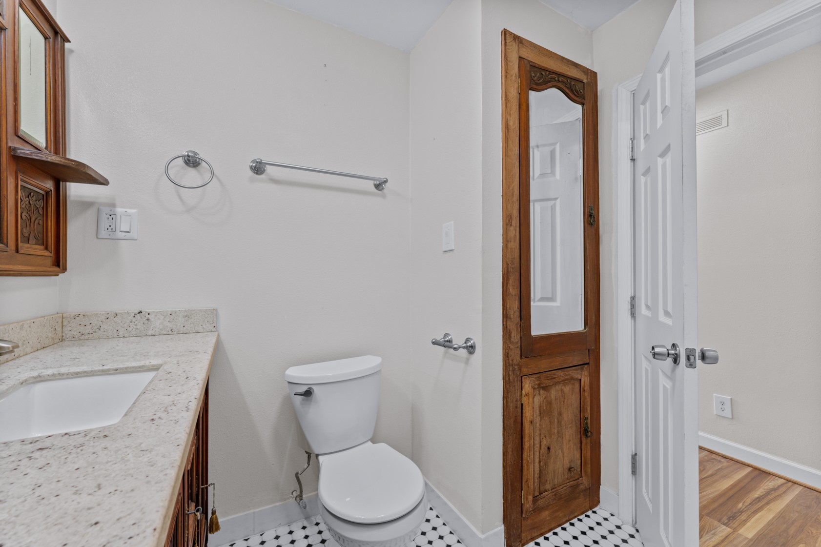 The wood door on the right is a linen closet for storage and has an inset mirror.
