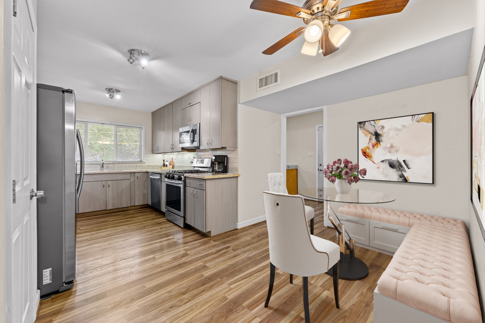 The breakfast nook is perfect for banquette-style seating!  The doorway in the center leads to the laundry room. Virtually staged.