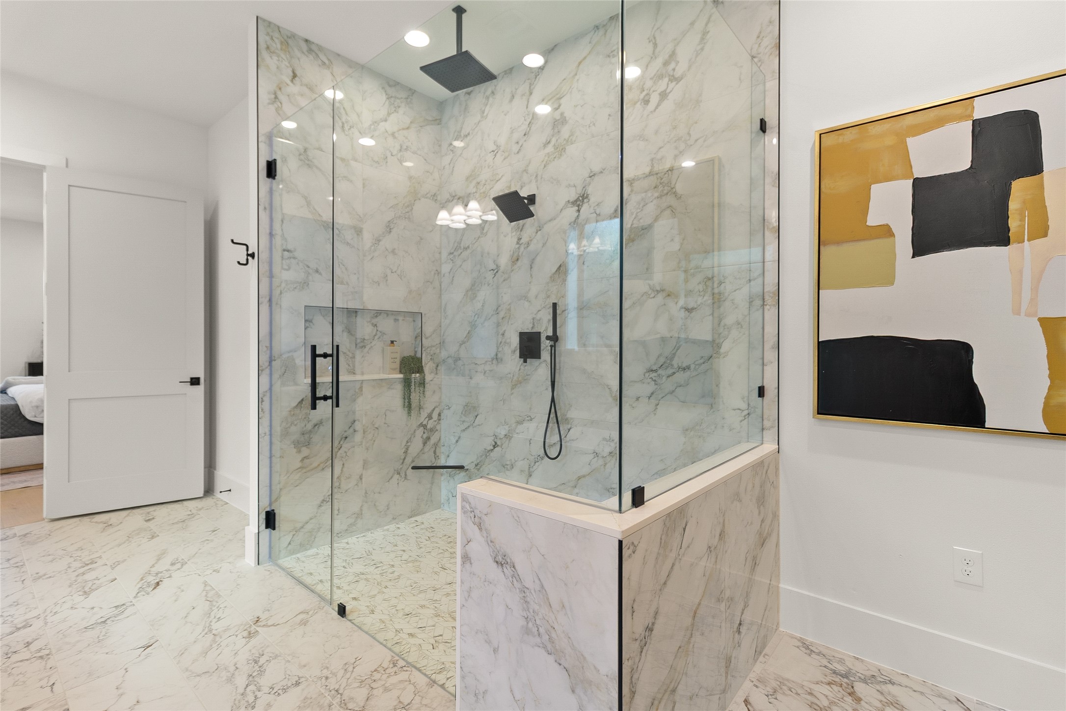 Every shower feels like a five-star experience in your expansive walk-in shower, wrapped in marble-look tile with dual rainfall showerheads and sleek frameless glass.