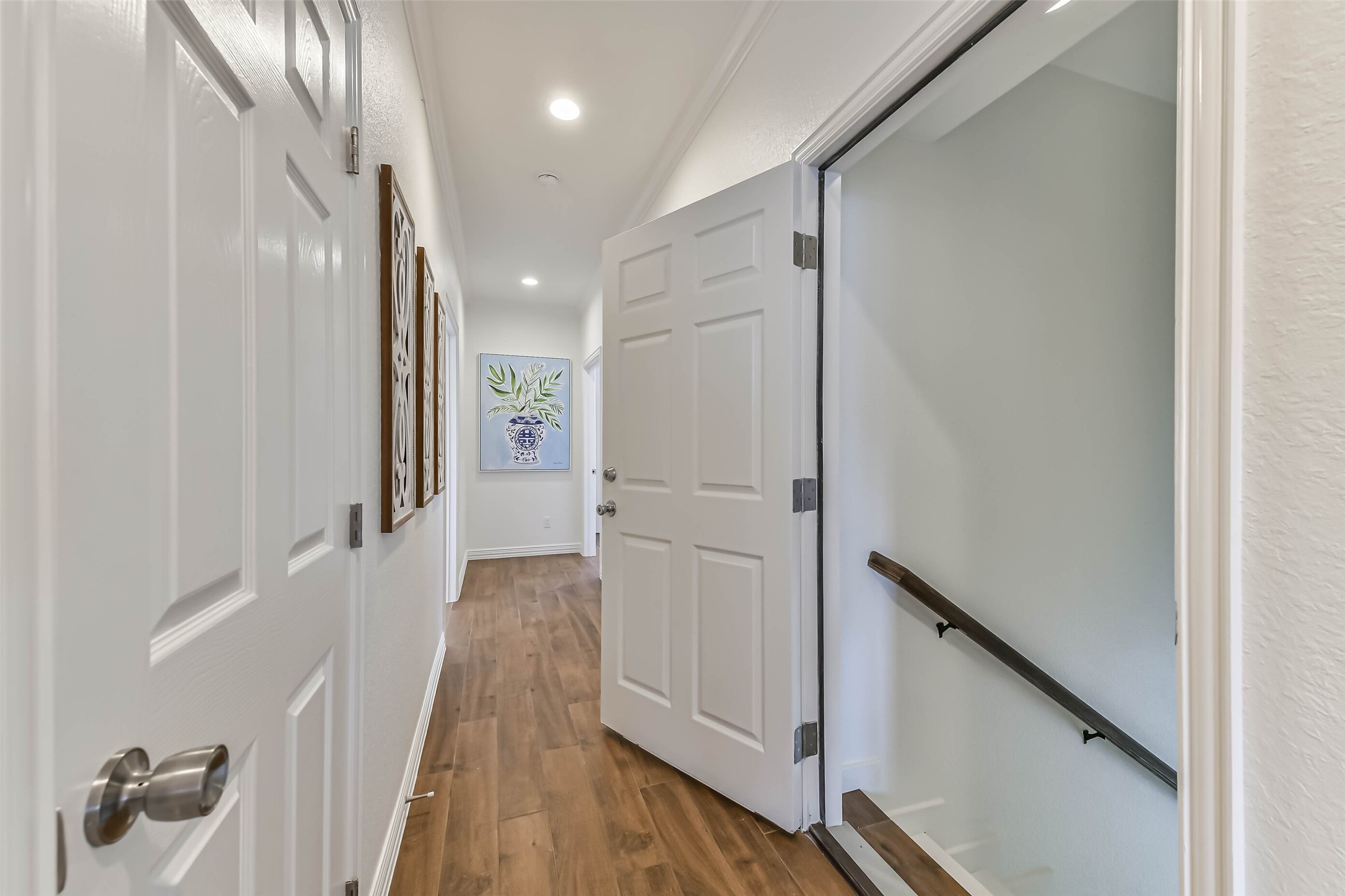 Neutral finishes and recessed lighting create a welcoming transition space between bedrooms.