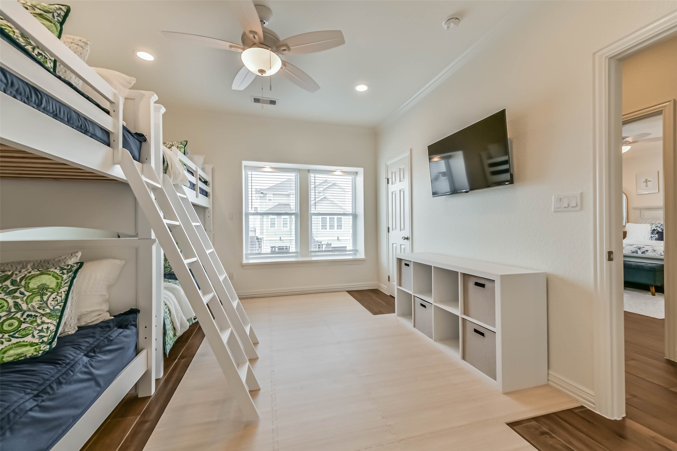 Well-designed bunk room offers multiple sleeping areas, natural light, and functional storage, ideal for guests or coastal getaways.