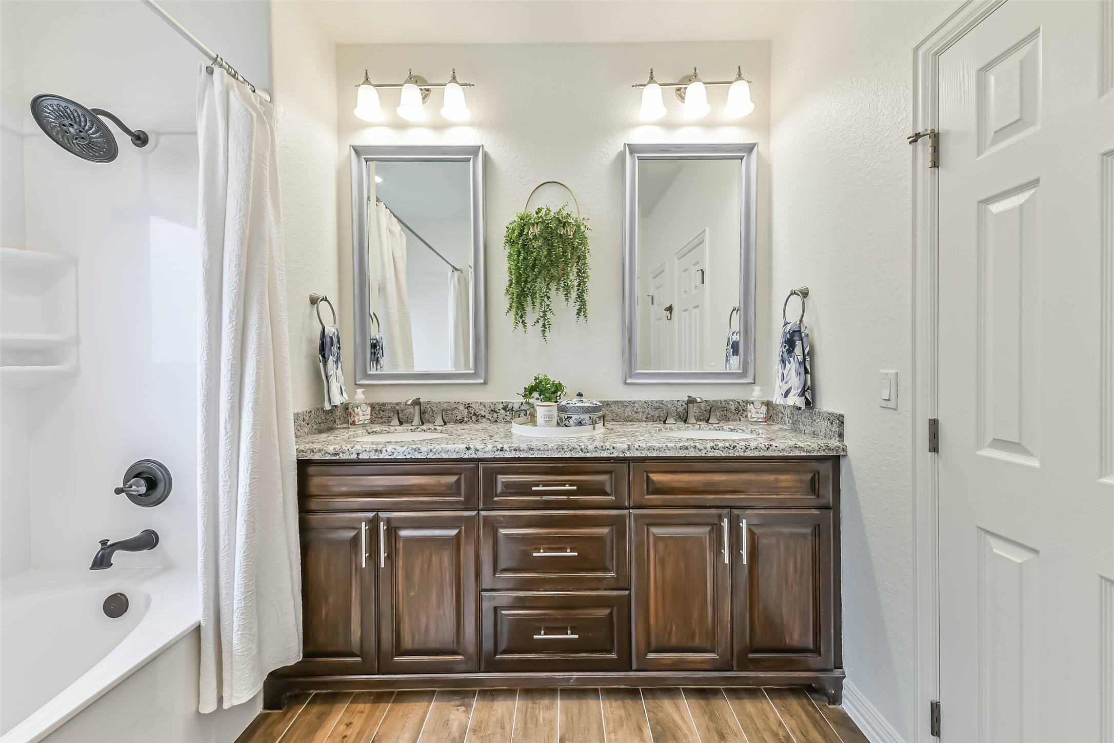 Well-maintained bath includes double sinks, neutral finishes, and convenient layout for guests or family use.