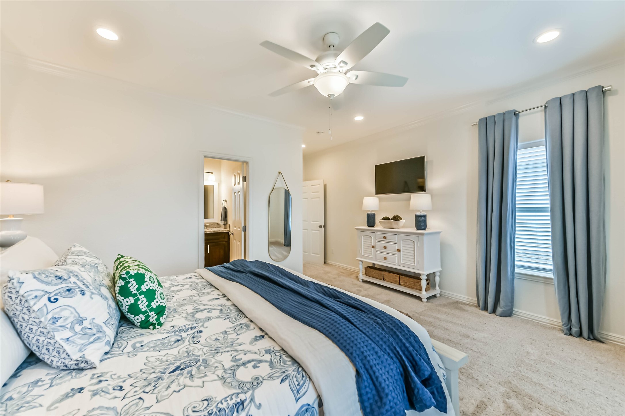Comfortable guest bedroom features carpet flooring, ceiling fan, natural light, and coordinated furnishings that convey with the home.