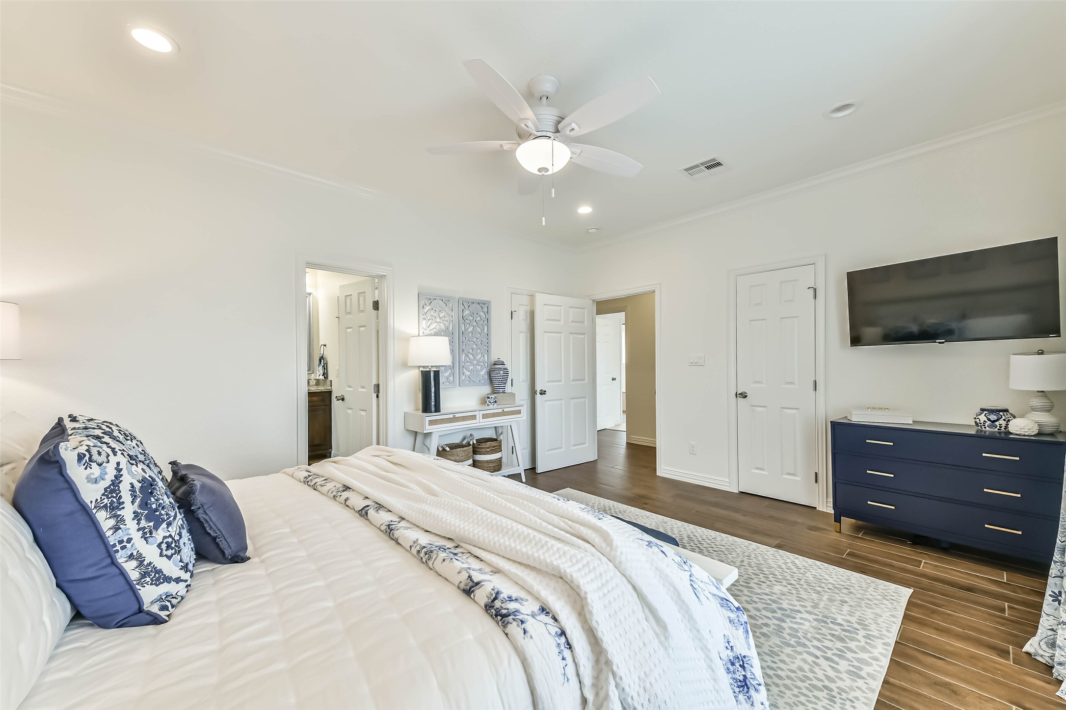 Inviting secondary bedroom offers natural light, durable flooring, and move-in-ready furniture that conveys with the home.
