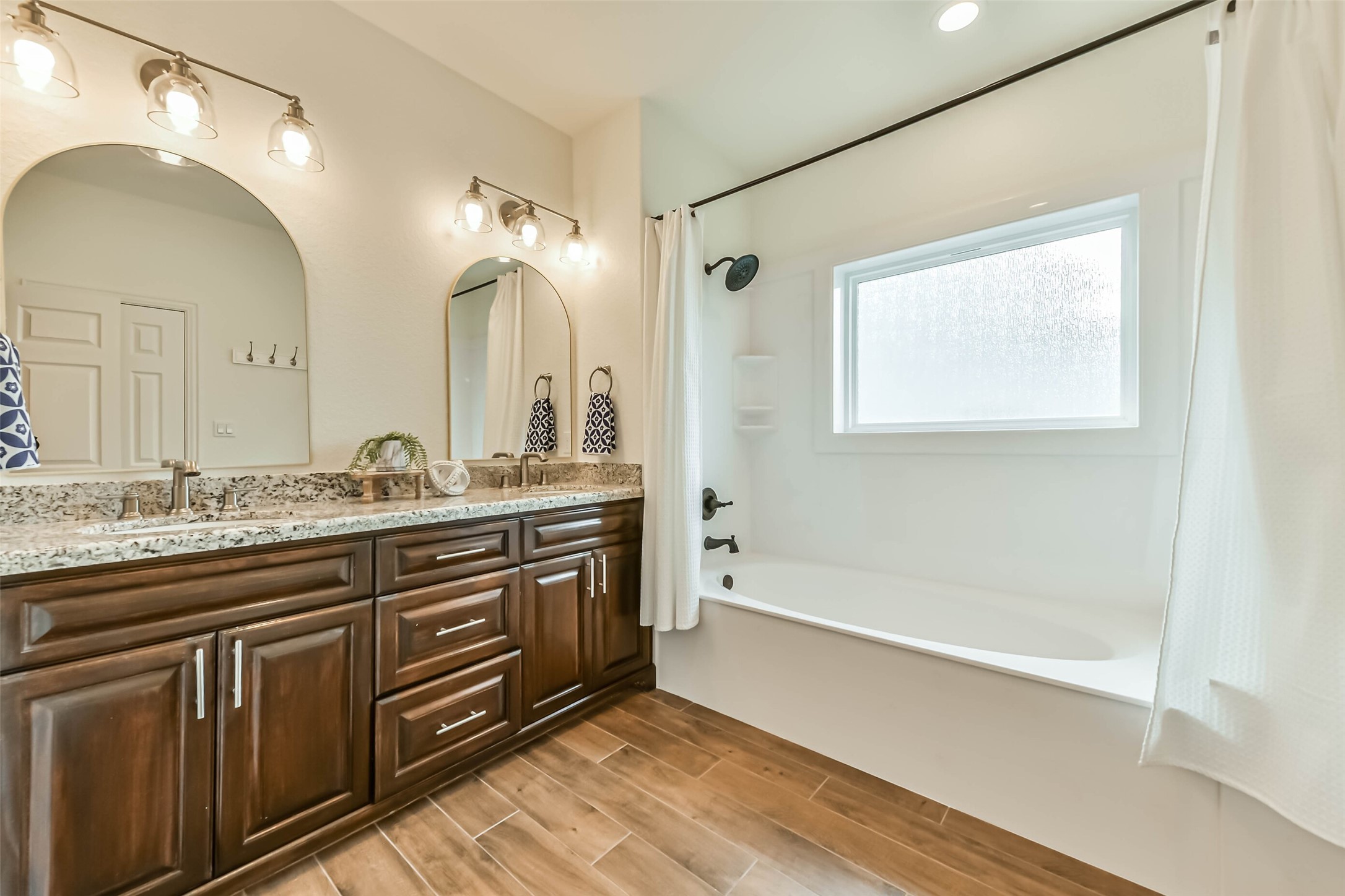 Neutral tones, stylish lighting, and durable flooring create a clean and functional bathroom environment.
