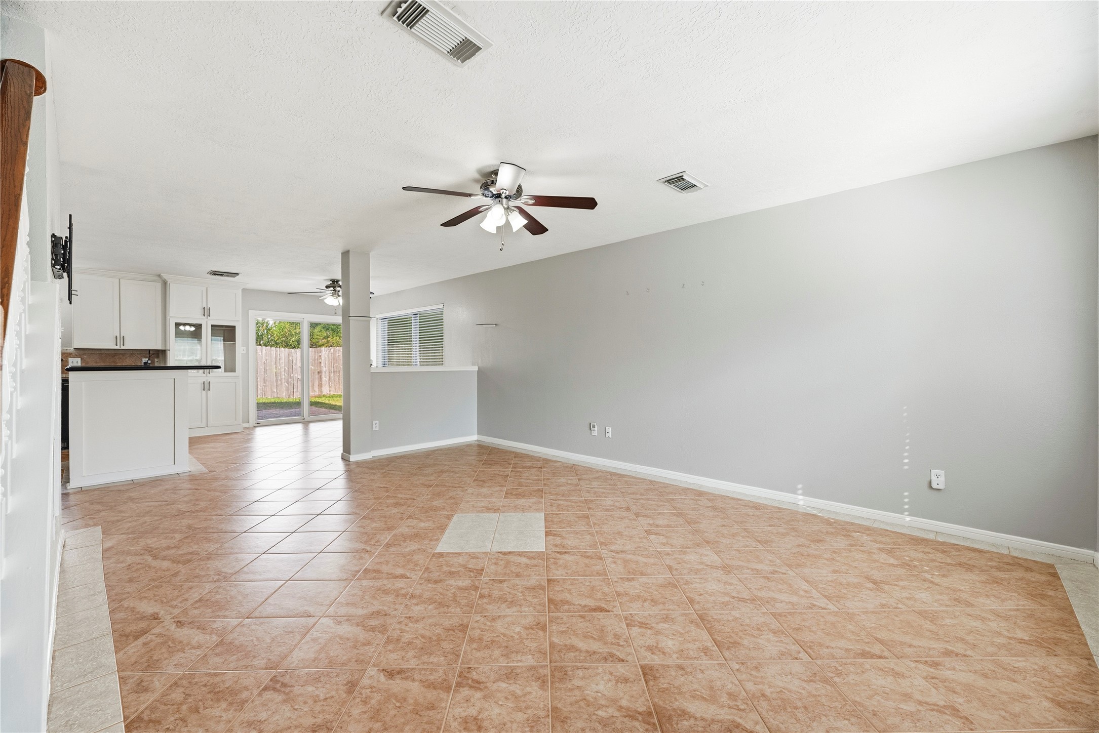 The family room is at the front of the home and features tile flooring and a ceiling fan.