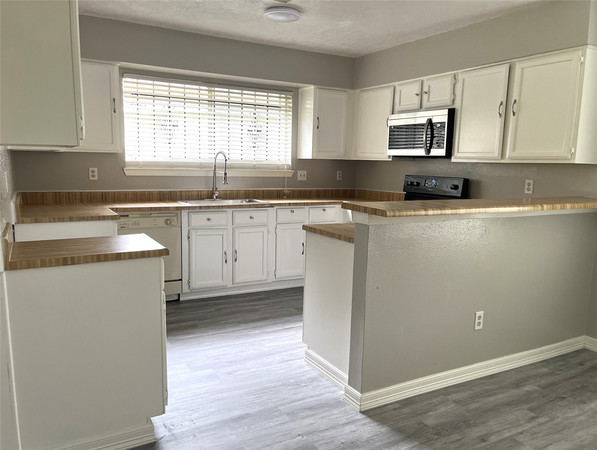 Kitchen with breakfast bar & white cabinetry