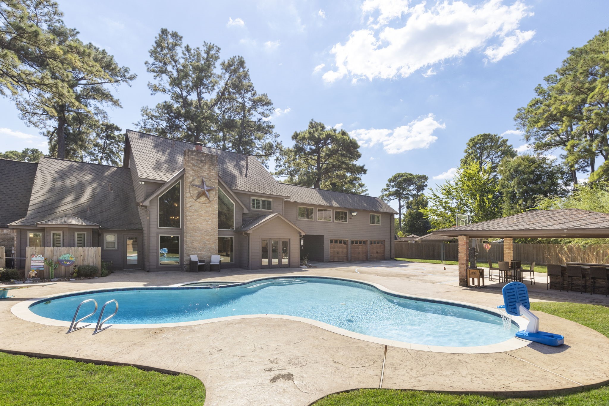 Sparkling pool & spa with diving board, huge covered summer kitchen, basketball court and more all with tree top nature views.
