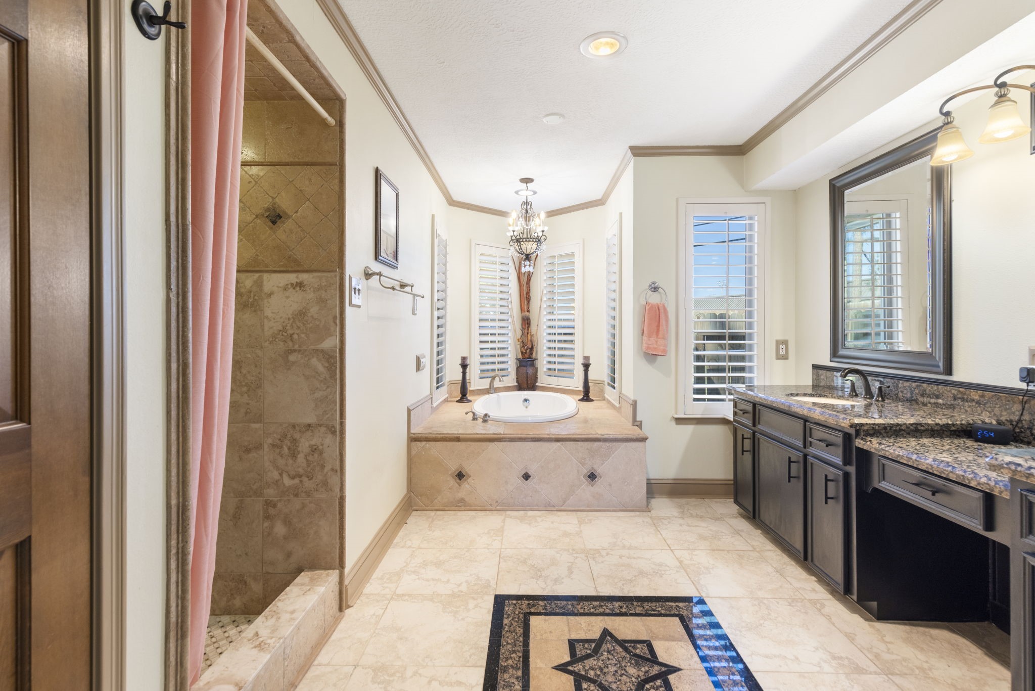Primary bathroom with separate walk-in shower and luxurious corner tub.