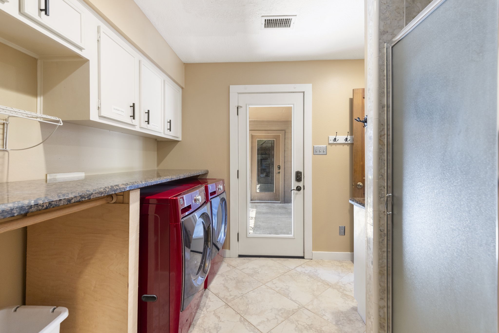 Large utility room with incredible storage, broom closet, granite countertops and direct access to the porte cochere and garage.
