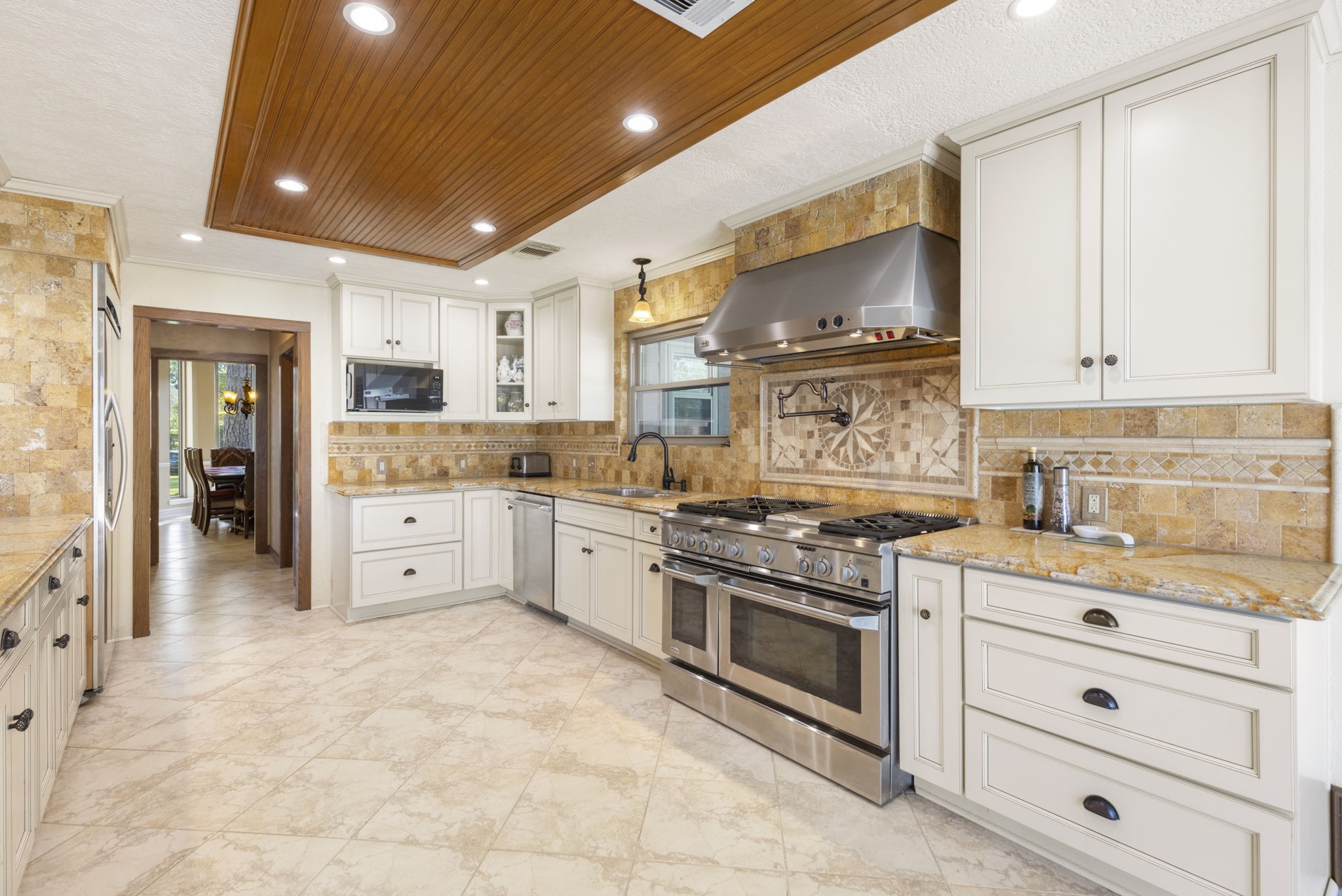 No shortage of details in this custom kitchen including the wood ceiling inlay, custom lighting & custom cabinets.