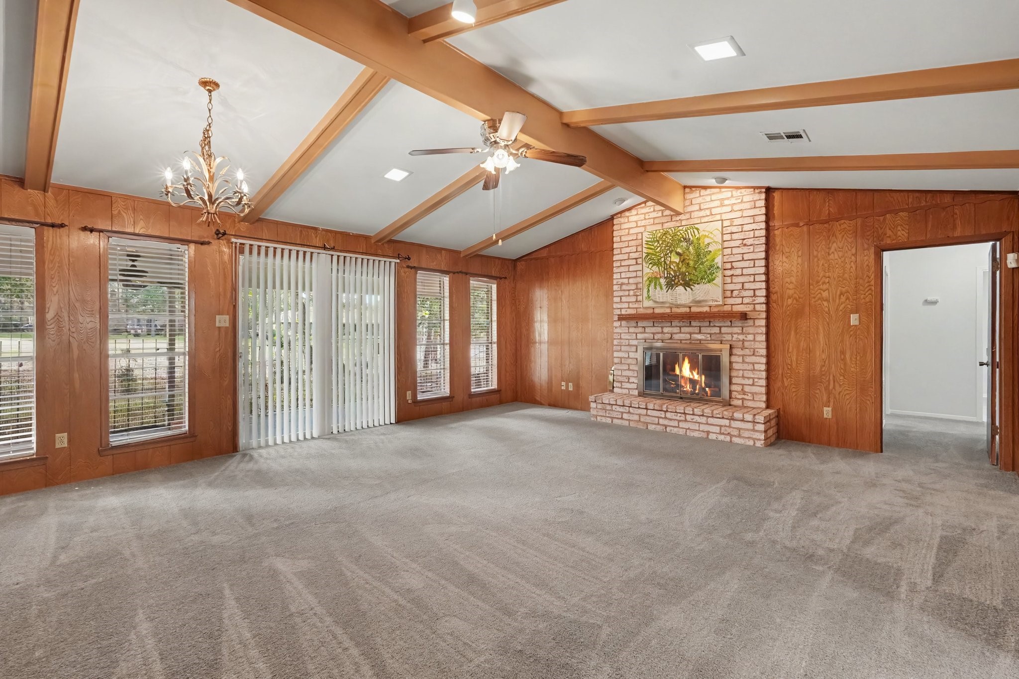 This wonderfully spacious family room offers ample area for a casual dining setup, perfectly complemented by a beautiful chandelier that anchors the room.