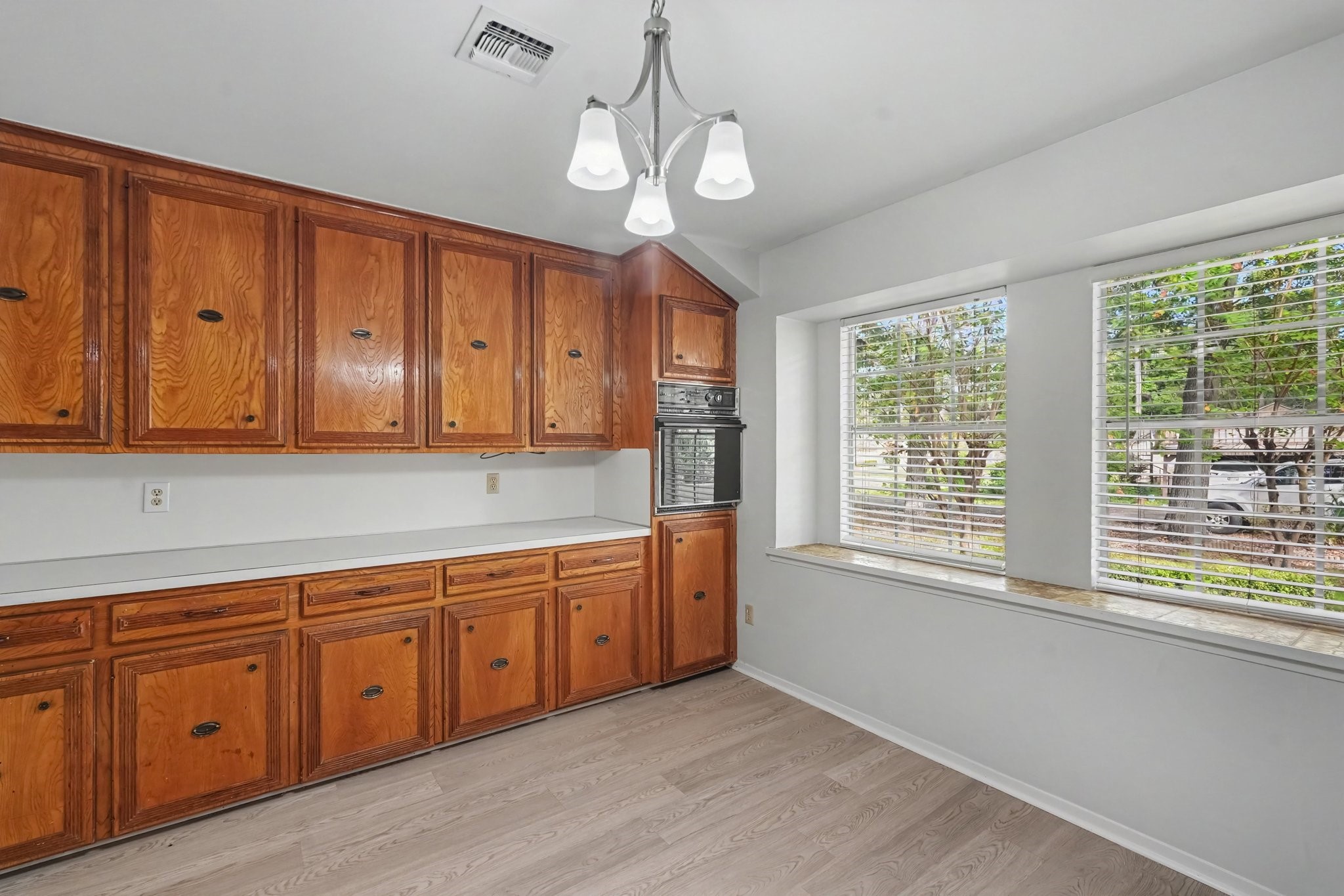This kitchen offers abundant storage with ample cabinetry, drawers, and a convenient built-in oven. The spacious layout is perfect for serving meals buffet-style during gatherings and provides plenty of room to create a cozy eat-in dining area.