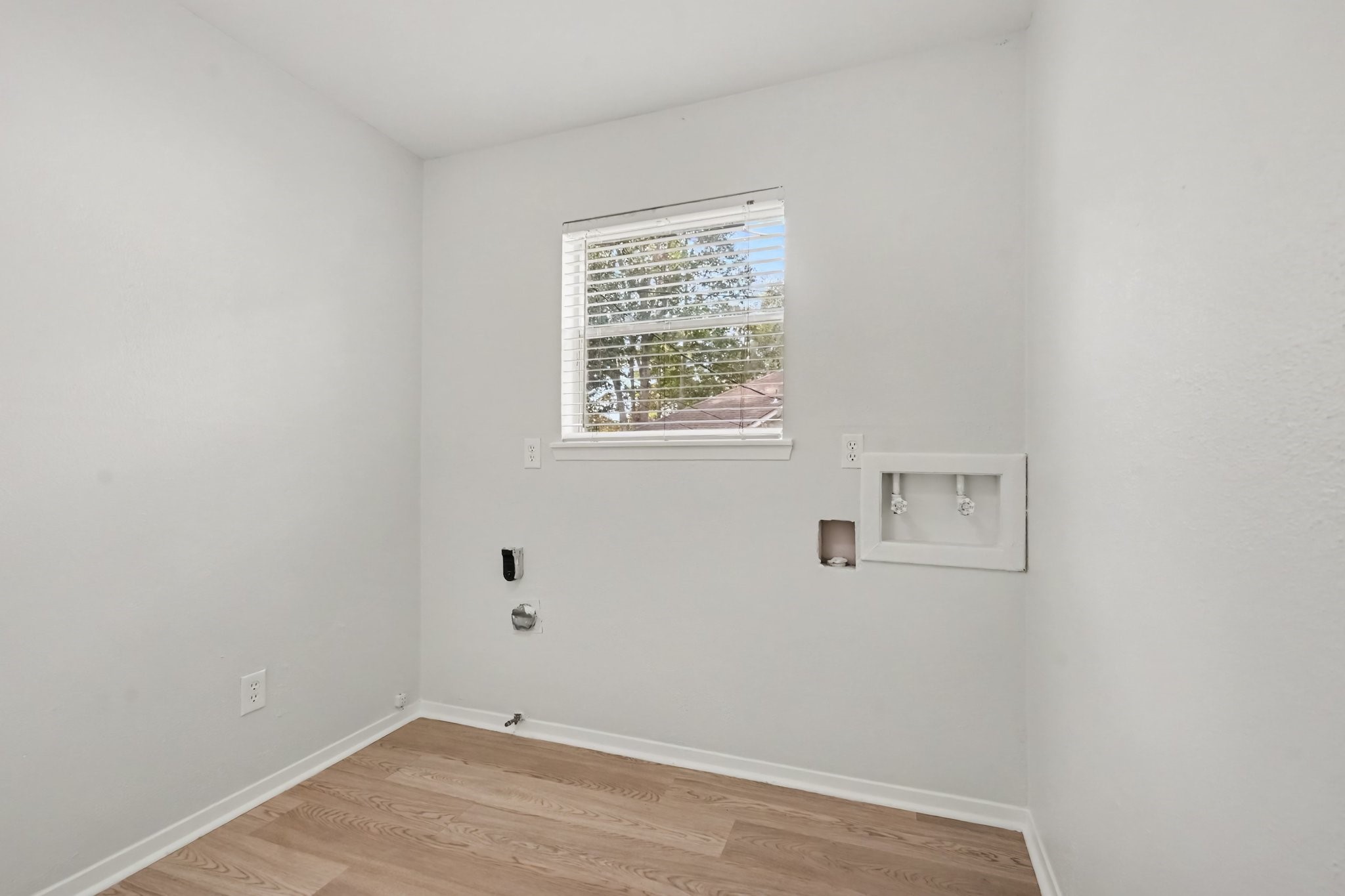 Bright, sun-filled laundry room featuring ample space and natural light.