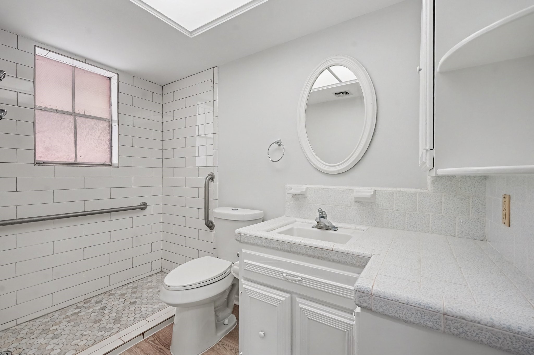 Bright and spacious oversized walk-in shower featuring accessible design elements, modern finishes, and built-in storage.