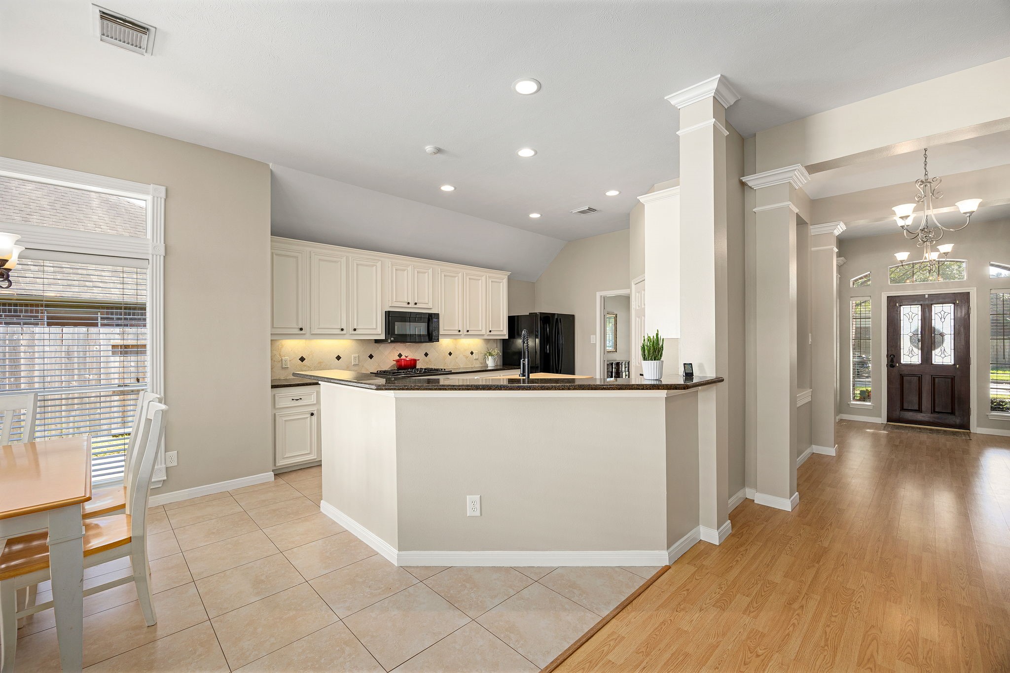 The kitchen offers crisp white cabinetry, granite countertops, a breakfast bar, and recessed lighting throughout. The kitchen offers crisp white cabinetry, granite countertops, a breakfast bar, and recessed lighting throughout.