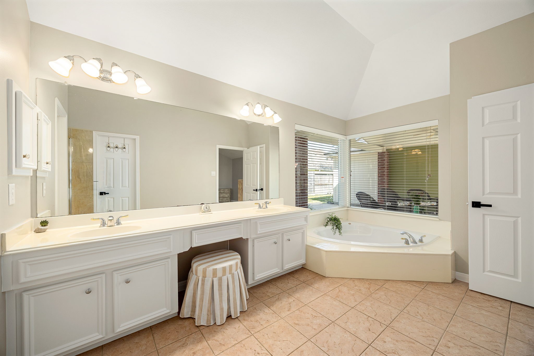 The ensuite primary bath offers a corner soaking tub paired with a double-sink vanity, perfect for unwinding after a long day.