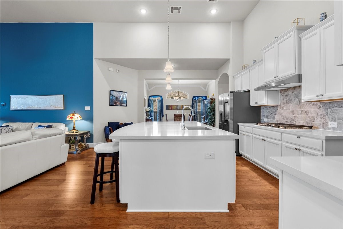Chef's eat-in island kitchen features 42" cabinets with crown molding, quartz countertops, and stainless steel appliances