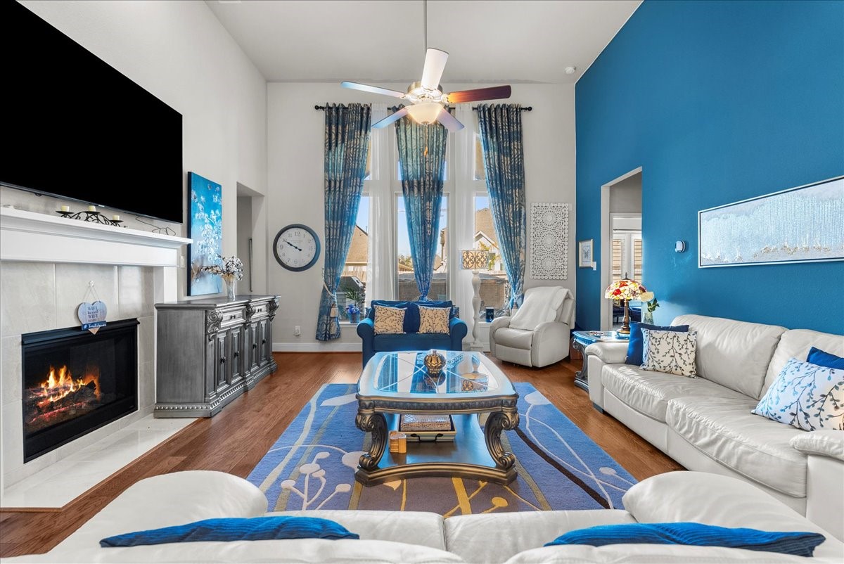 The living room features a cozy fireplace, high ceilings and a wall of windows