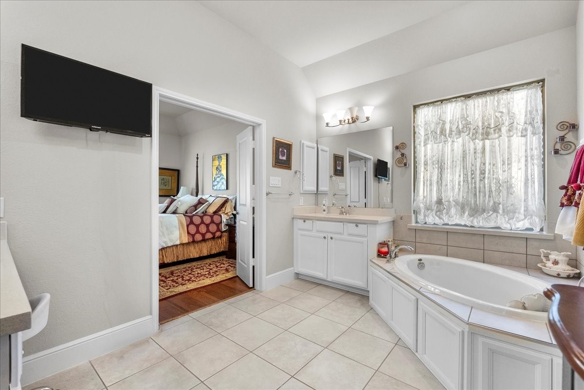The primary en-suite bath offers dual vanities, a walk-in shower, soaking tub and custom walk-in closet
