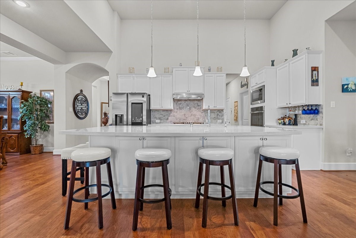 Chef's eat-in island kitchen features 42" cabinets with crown molding, quartz countertops, and stainless steel appliances