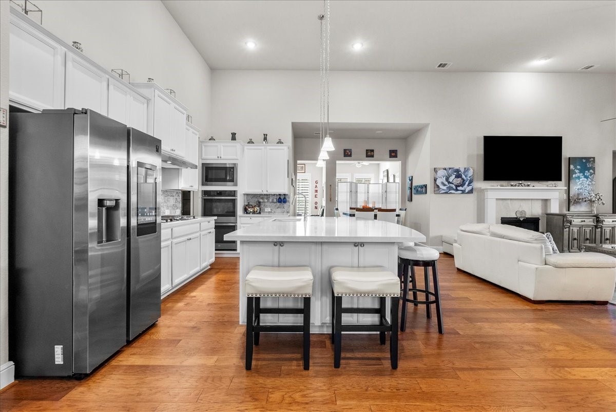 Chef's eat-in island kitchen features 42" cabinets with crown molding, quartz countertops, and stainless steel appliances