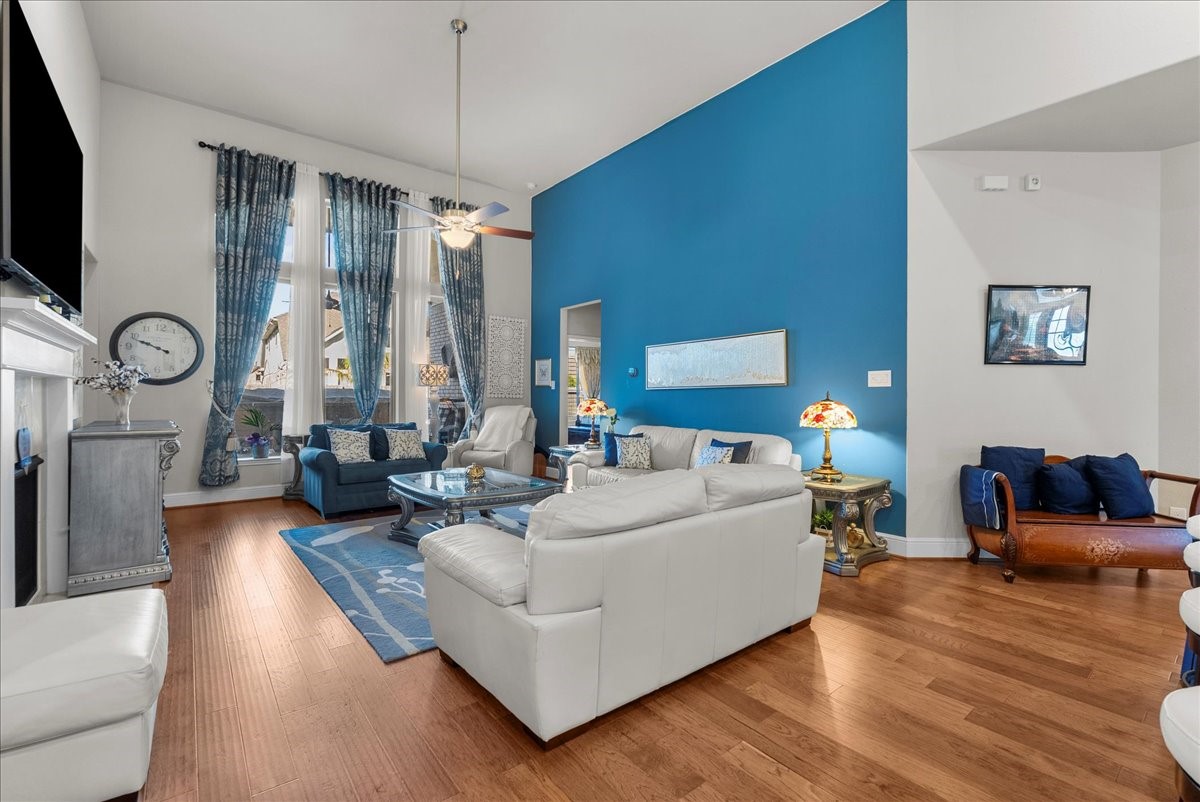 The living room features a cozy fireplace, high ceilings and a wall of windows