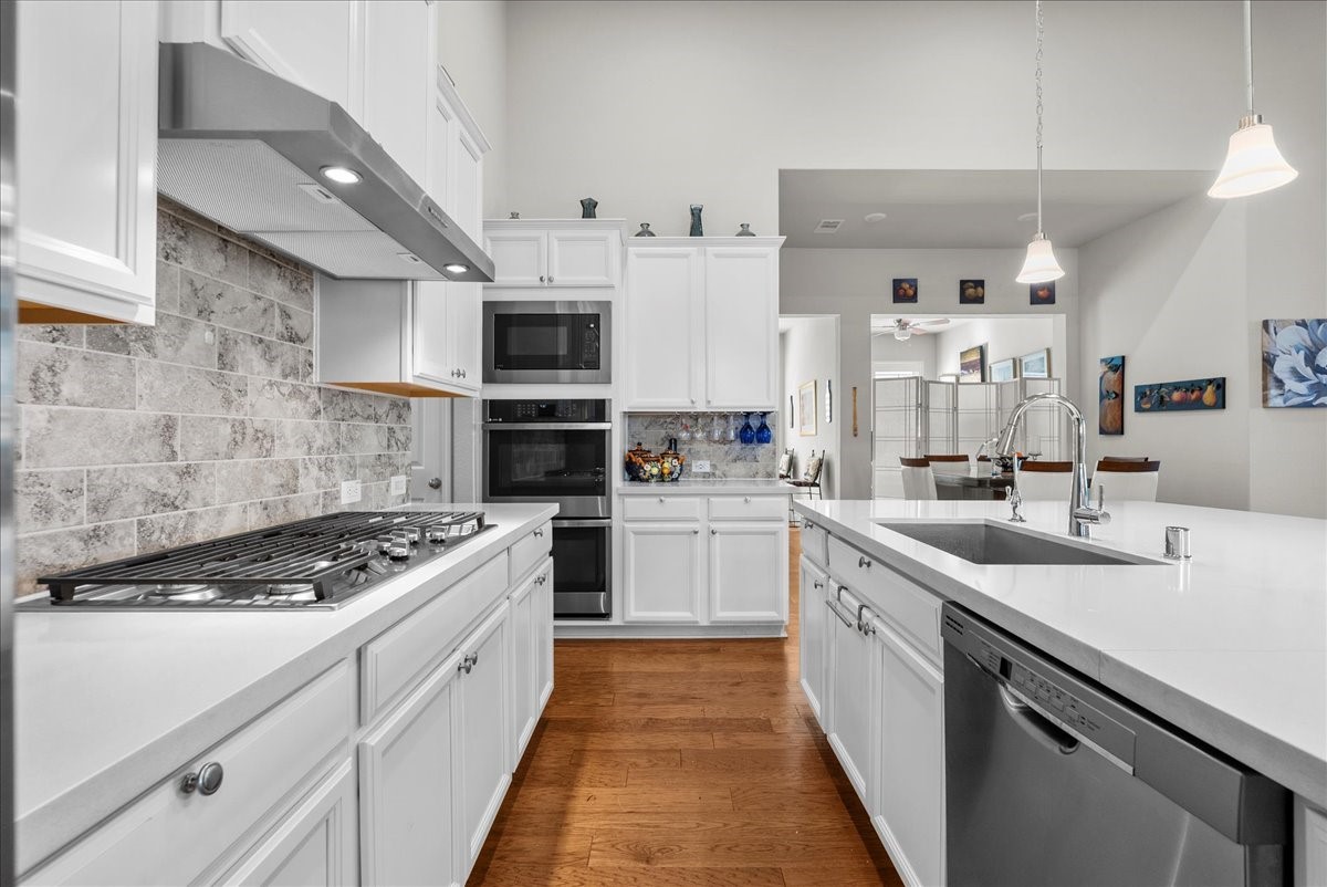Chef's eat-in island kitchen features 42" cabinets with crown molding, quartz countertops, and stainless steel appliances