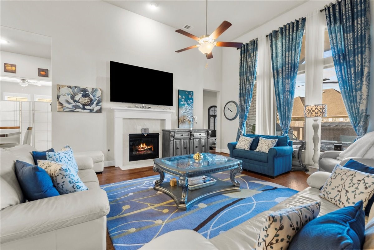 The living room features a cozy fireplace, high ceilings and a wall of windows